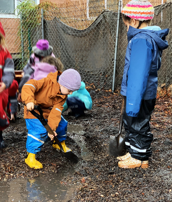 Kindergarten children digging mud