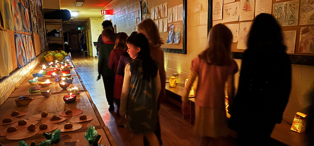 Gr 2 students walk down the hallway admiring lit diyas and lanterns